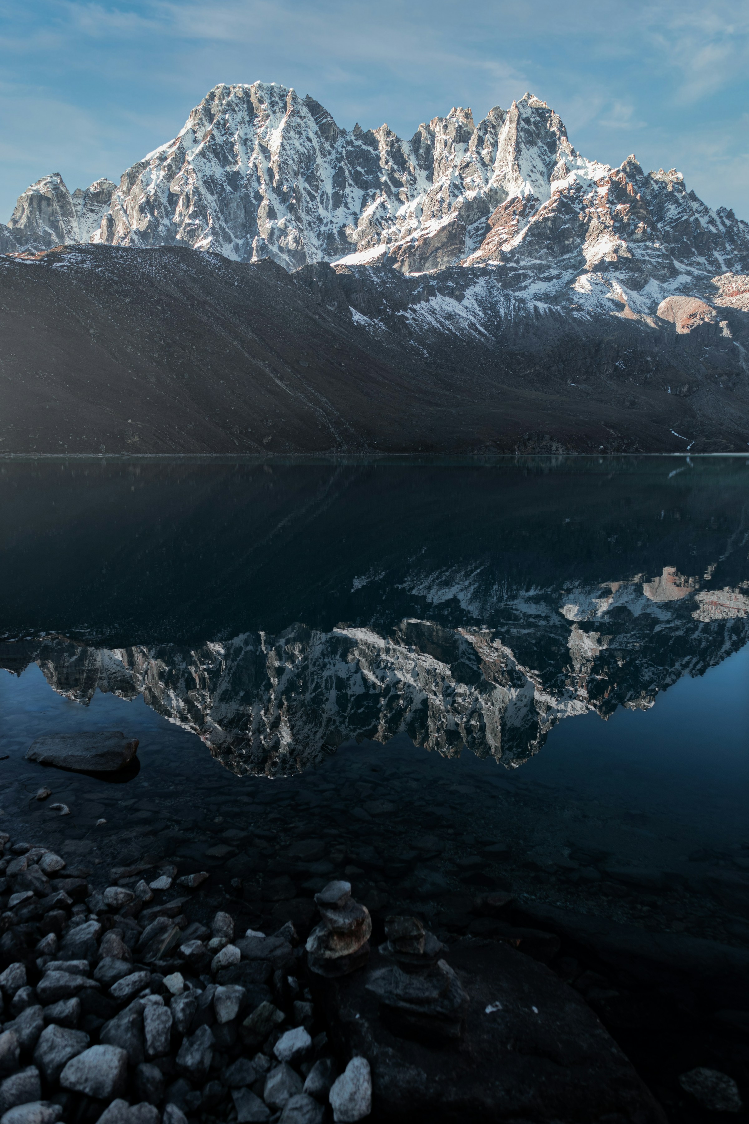 A still glacial lake reflecting a snow-covered mountain range at Gokyo